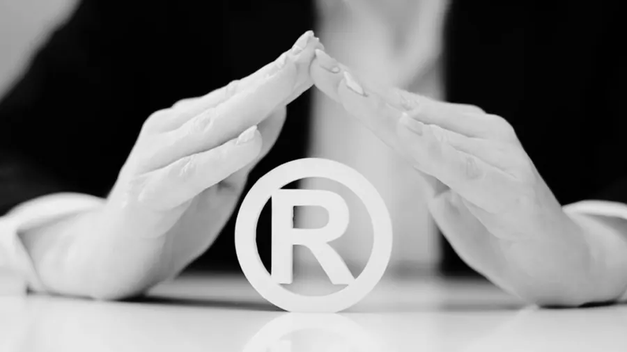 Mãos protegendo o símbolo de marca registrada